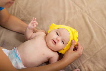 Young woman dressing a baby
