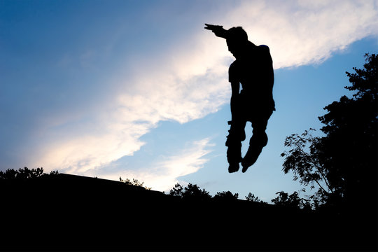silhouette of a skater in a jump against the blue sky