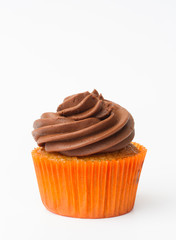 A chocolate orange cupcake with swirled frosting on an isolated white background.