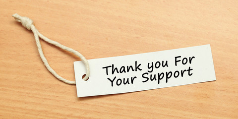 White tag on wooden background with word quotes of Thank you For Your Support