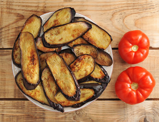 fried eggplant on the plate and two tomatoes