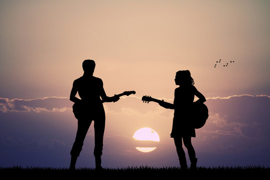 people with guitar at sunset