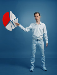 Man in white shirt working with pie chart on blue background.