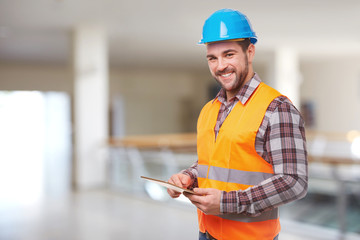 Fototapeta premium Manual worker in blue helmet using a digital tablet