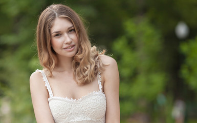 Naklejka premium Portrait Of Young Beautiful Woman. beautiful young brunette fashion model posing outdoor. Summer outdoor portrait. Focus on woman, blurred background
