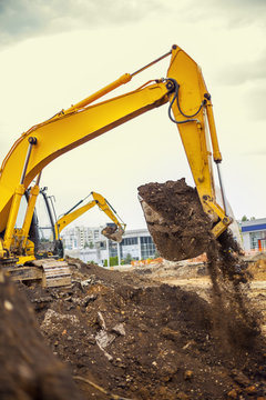 Two excavators are digging earth on the construction site.