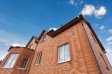 Fototapeta na wymiar Beautiful new brick hoouse with plastic windows and metal tiler roof