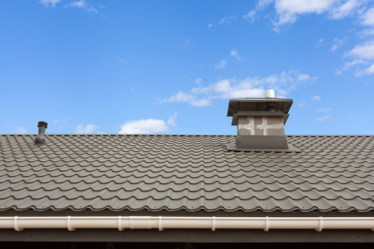 New gray metal tile roof with chimney