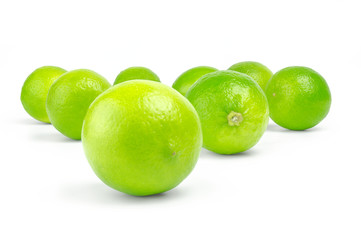 scattering of fresh green citrus limes on white background
