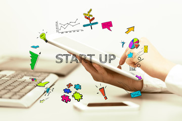 Young business woman pointing at Start Up concept and uses table
