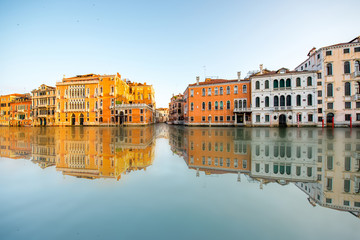 Fototapeta na wymiar Beautiful waterfront with colorful buildings on Gran canal in Venice at the sunrise. Long exposure image technic with reflection on the water