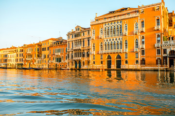 Naklejka premium Beautiful waterfront with colorful gothic buildings and boats on Gran canal at the sunrise