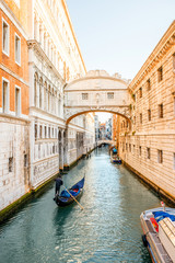 Fototapeta na wymiar Water canal with famous bridge of Sights with gondola near Doges palace in Venice