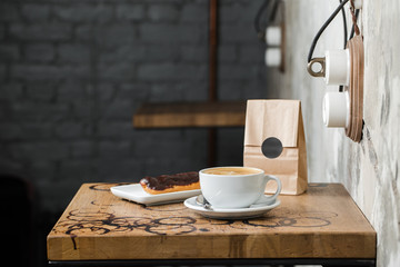 cappuccino flatwhite coffee with eclair on table