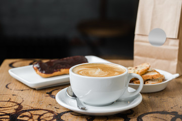 cappuccino flatwhite coffee with eclair on table
