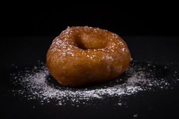 Sprinkling sugar powder on donut