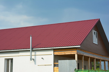 Building new red metal roof house construction