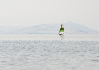 A peaceful boat sailing on the Great Salt Lake with mountains in the background.