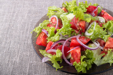 Side view on a plate with fresh salad of raw vegetables closeup