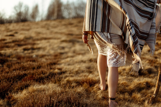 woman legs in boho dress walking on windy mountain