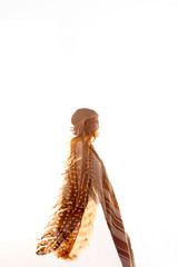 double exposure of boho woman and feathers in sky