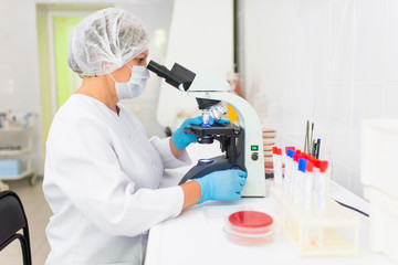 laboratory woman looking through a microscope