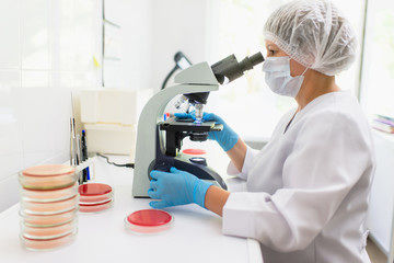 laboratory woman looking through a microscope
