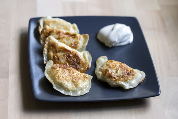 Fried dumplings (called pierogi) with sour cream. Traditional polish food.
