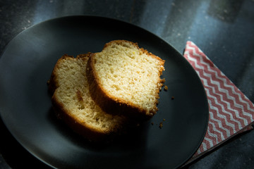 Lemon Cake served in a black plate.