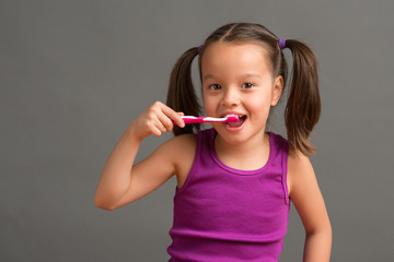 5 year old kid brushing her teeth