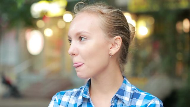 shy girl in the street. squint at the sides. licking lips