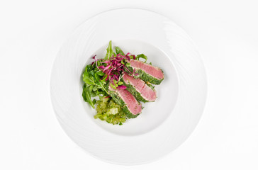 Tuna in herbs with ginger melon on a plate on a white background, top view