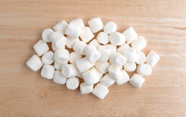 Fototapeta na wymiar Small marshmallows on a wood cutting board.