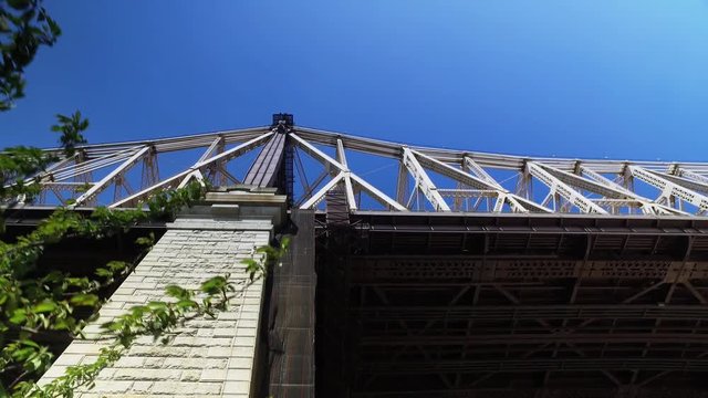 A low angle daytime establishing shot of the Ed Koch Queensboro Bridge between Manhattan and Brooklyn.  	