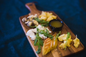 Beautifully decorated catering banquet table with different food snacks and appetizers with sandwich, caviar, fresh fruits on corporate open-air party event or wedding celebration