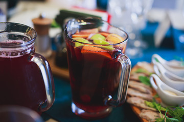 Beautifully decorated catering banquet table with different food snacks and appetizers with sandwich, caviar, fresh fruits on corporate open-air party event or wedding celebration