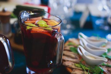 Beautifully decorated catering banquet table with different food snacks and appetizers with sandwich, caviar, fresh fruits on corporate open-air party event or wedding celebration