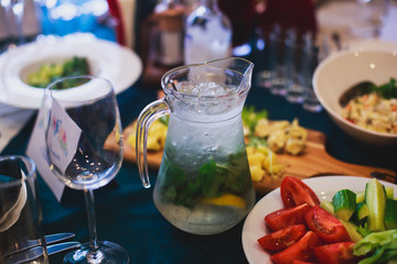 Beautifully decorated catering banquet table with different food snacks and appetizers with sandwich, caviar, fresh fruits on corporate open-air party event or wedding celebration