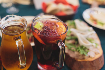 Beautifully decorated catering banquet table with different food snacks and appetizers with sandwich, caviar, fresh fruits on corporate open-air party event or wedding celebration