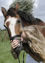 Foto auf Acrylglas knappe blonde jongvolwassen meid knuffelt met haar paard © monicaclick