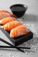 Salmon sushi on black wooden plate, closeup
