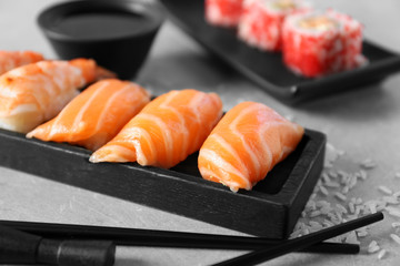 Salmon sushi on black wooden plate, closeup