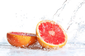 Fresh grapefruit in splashing water isolated on white