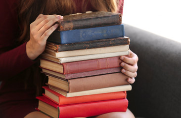 Woman holding stack of old books