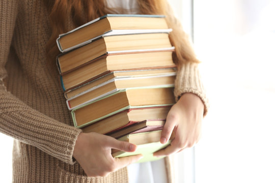 Woman Holding Stack Of Old Books