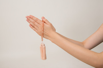 数珠で合掌する女性の手