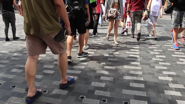 People at Siam Square step across a road by crosswalk or zebra crossing