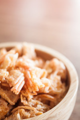 Fried shrimp chins snack in wooden bowl