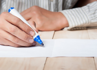 Close-up of Human Hand holding pen Signing on Formal Paper at the Table