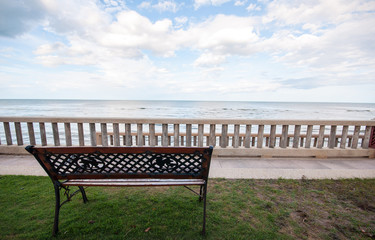 Fototapeta na wymiar Wooden bench with the look at blue sea and sky